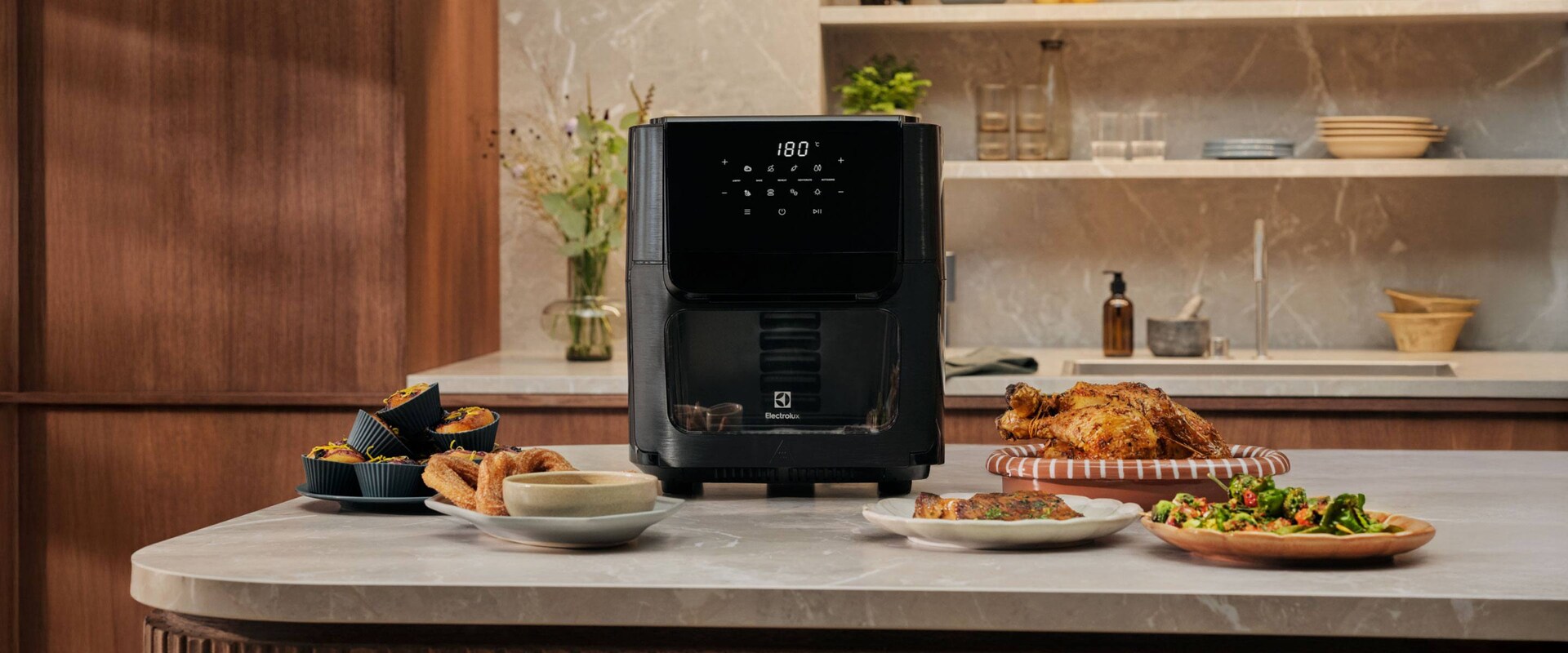 Sort airfryer med forskellige retter.